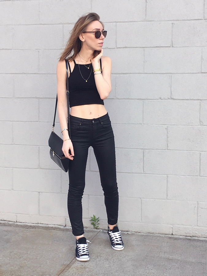 Girl wearing black outfit against white building