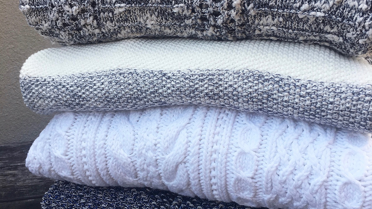 Four folded sweaters stacked