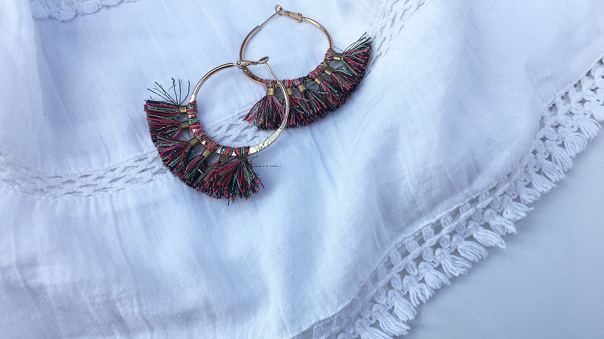 Gold hoops with colorful tassels and white shirt