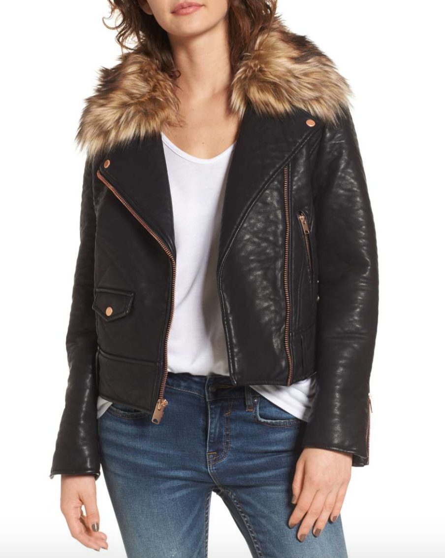 Model wearing Andrew Marc black faux leather jacket with fur trim