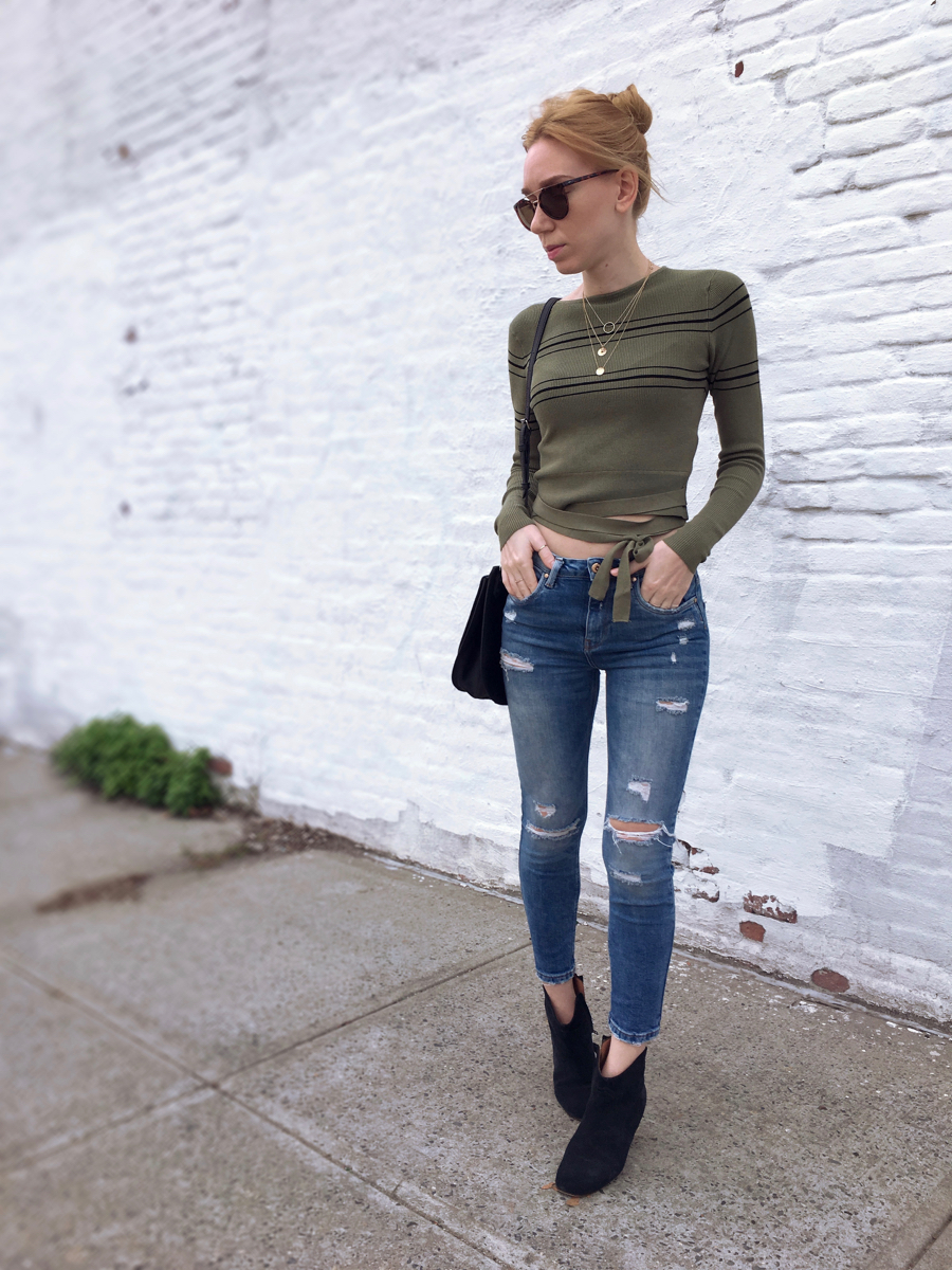Woman posing wearing jeans and a green cropped sweater