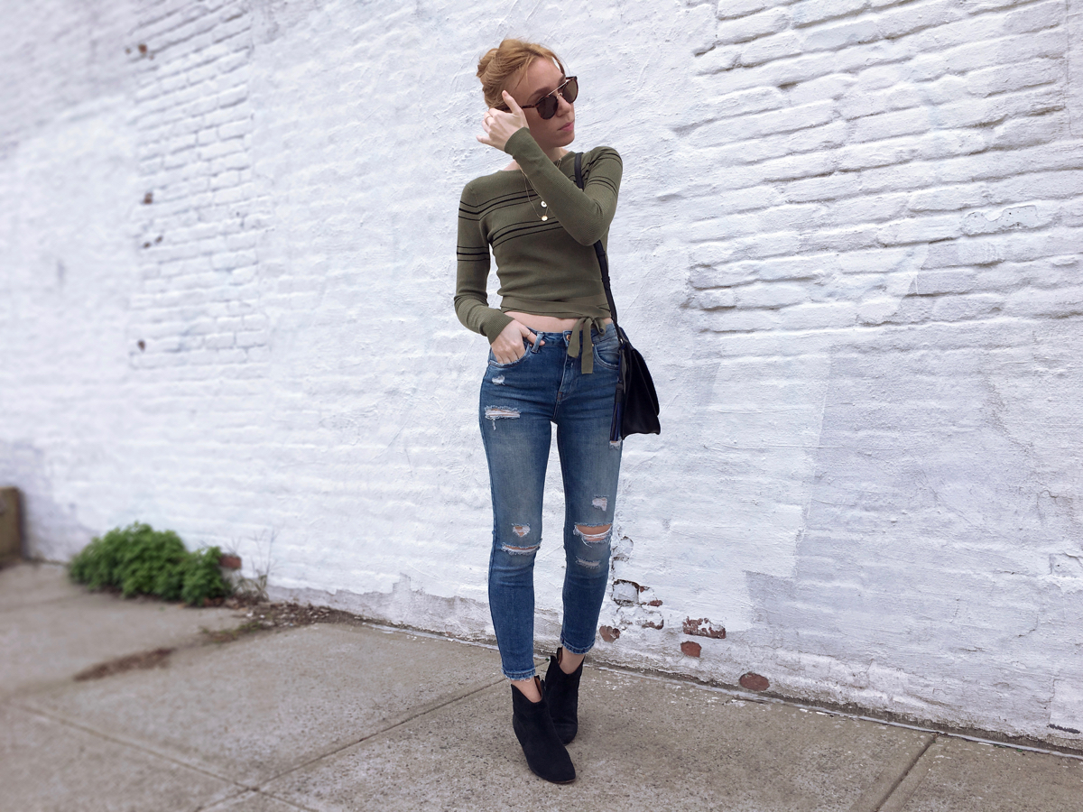 Woman posing wearing jeans and green cropped sweater