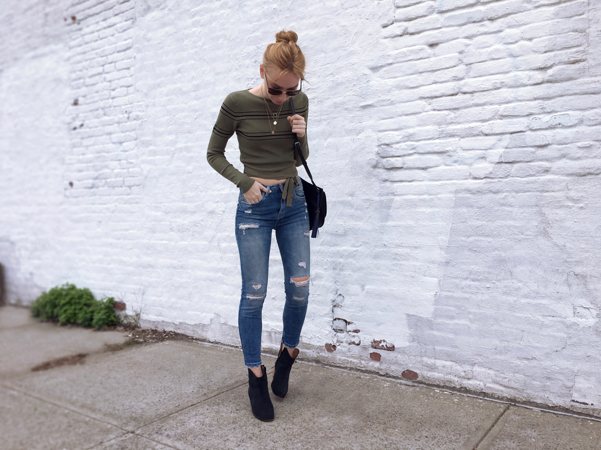 Woman posing wearing green cropped sweater with jeans and booties