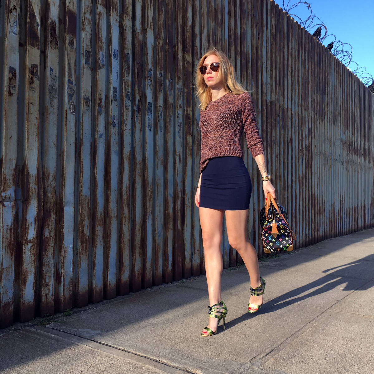 Woman posing in the street with Louis Vuitton bag