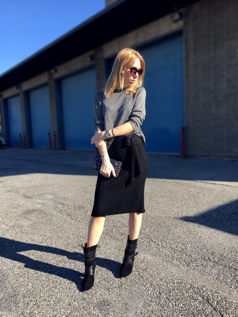 woman posing in pencil skirt with black boots and sweater