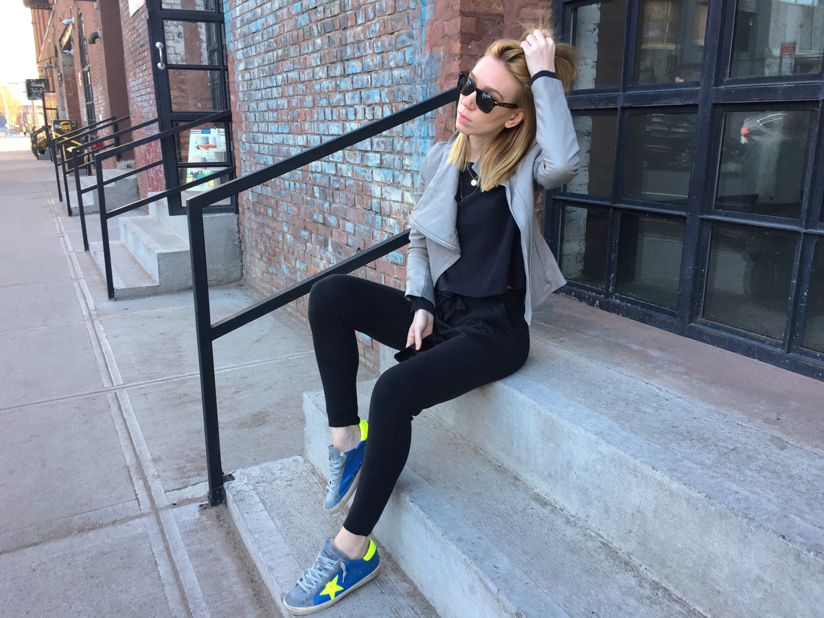 Woman sitting on steps wearing Golden Goose sneakers
