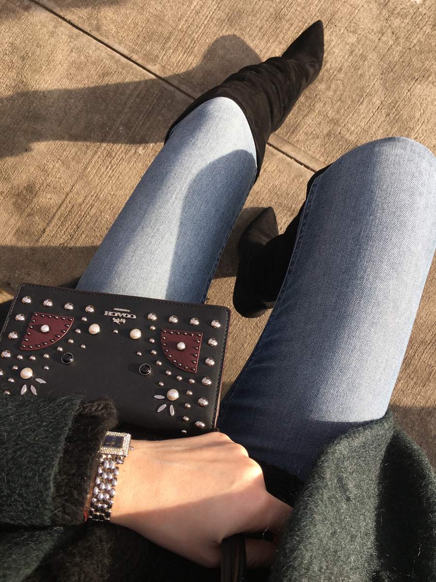 Detail shot of Coach studded bag and jeans