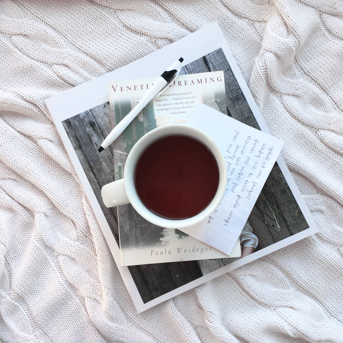 Coffee cup on top of a book and a magazine