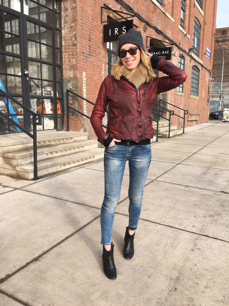 Woman posing wearing jeans and a red leather jacket