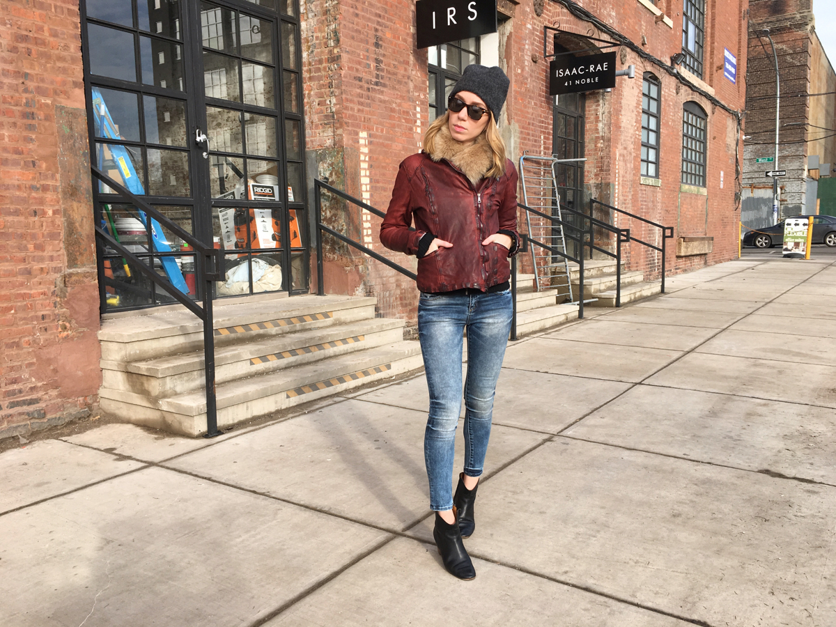 Woman posing in leather and jeans outfit with booties