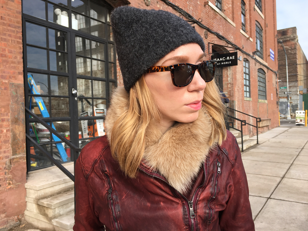 Woman looking sideways wearing leather and a hat