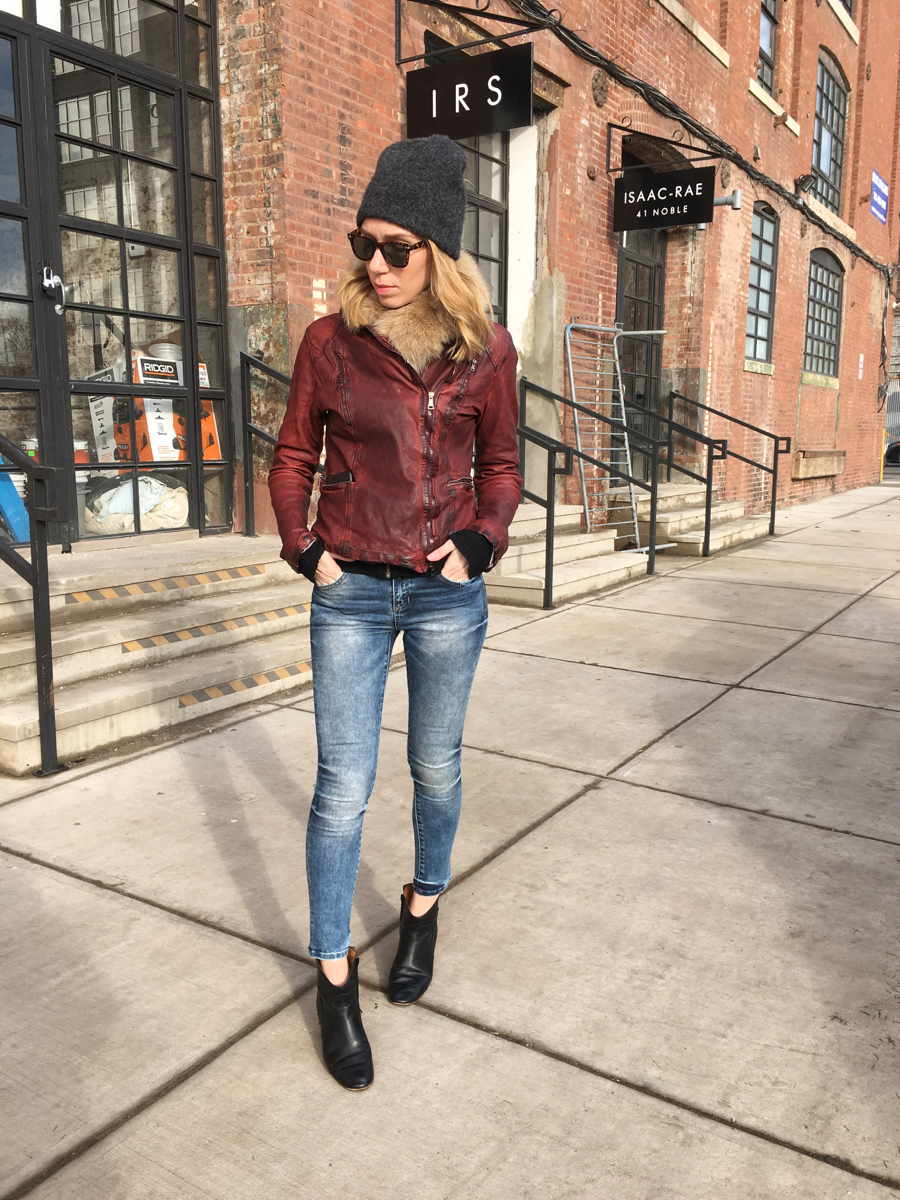 Woman posing in leather jacket and jeans outfit