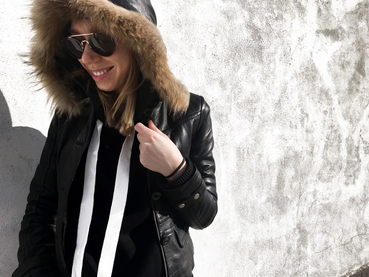 Woman smiling wearing black leather jacket and hoodie