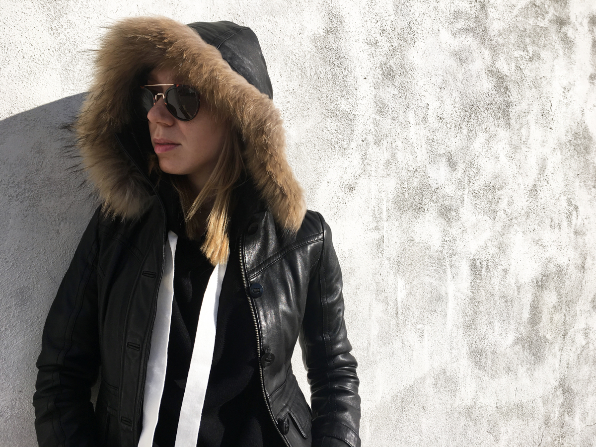 Woman looking sideways wearing black leather jacket