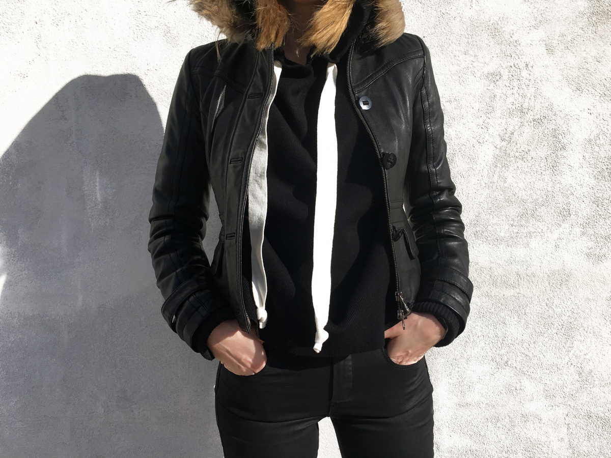 Detail shot of black leather jacket and hoodie