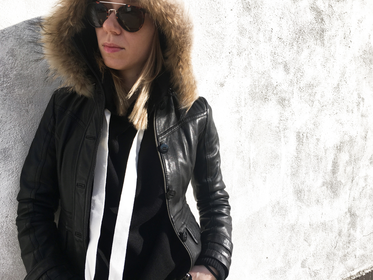 Zoomed in shot of woman wearing black hoodie with black leather jacket