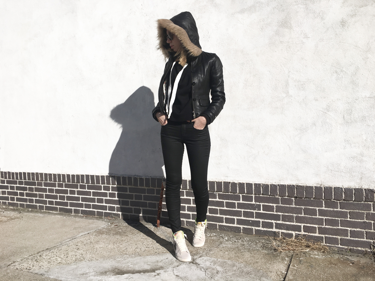 Woman looking sideways wearing all black outfit with sneakers