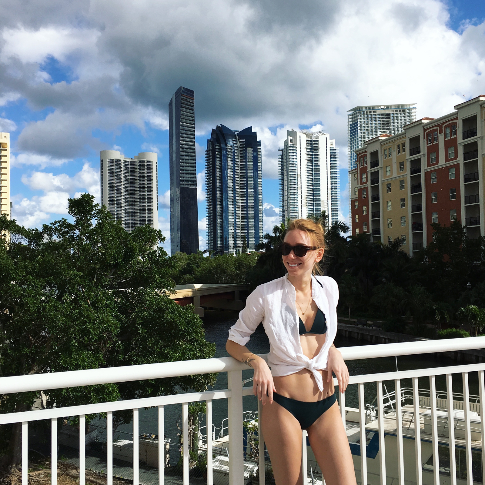 Woman posing in bathing suit with backdrop of Miami