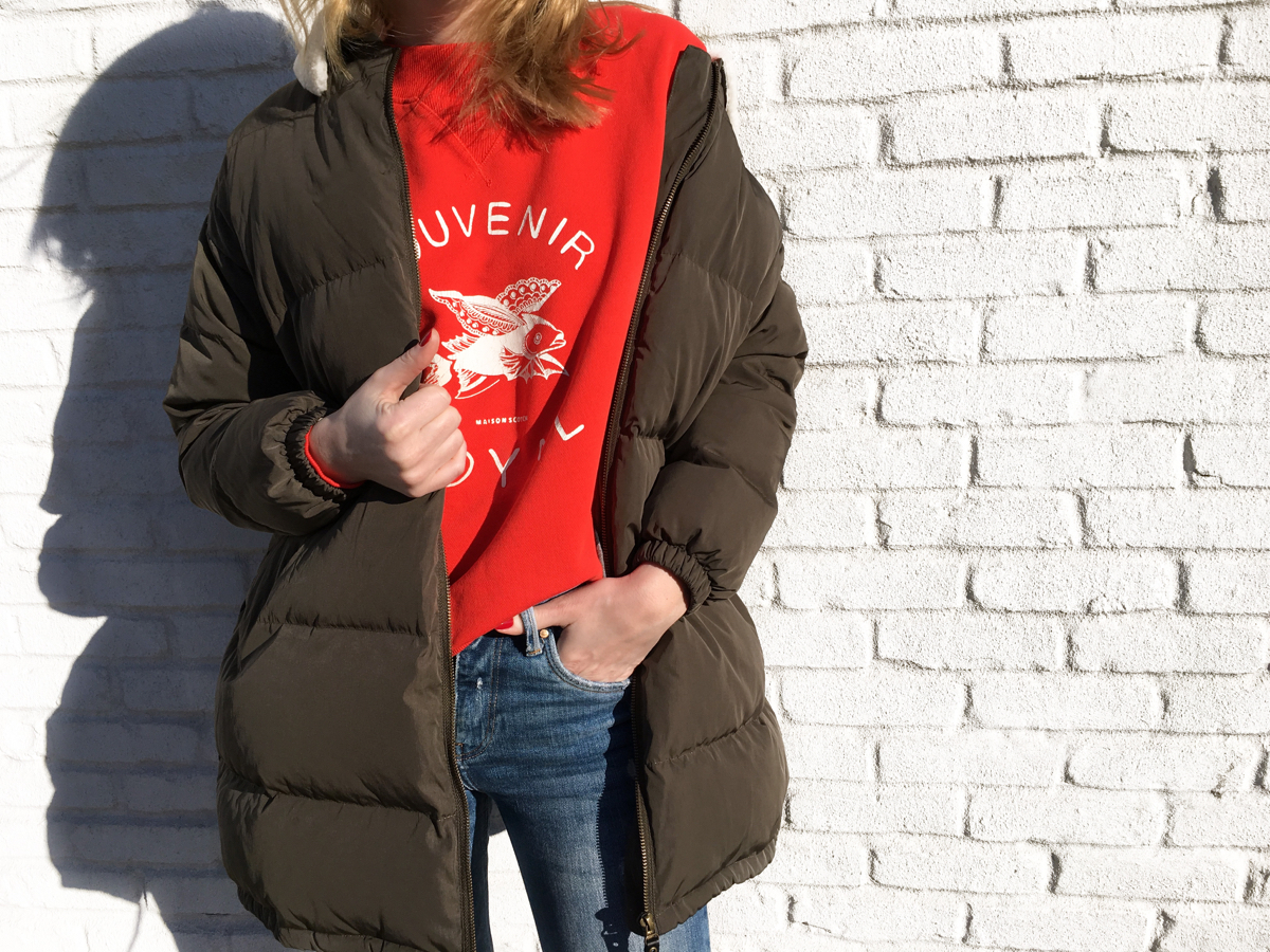 Detail shot of red sweater and olive colored coat