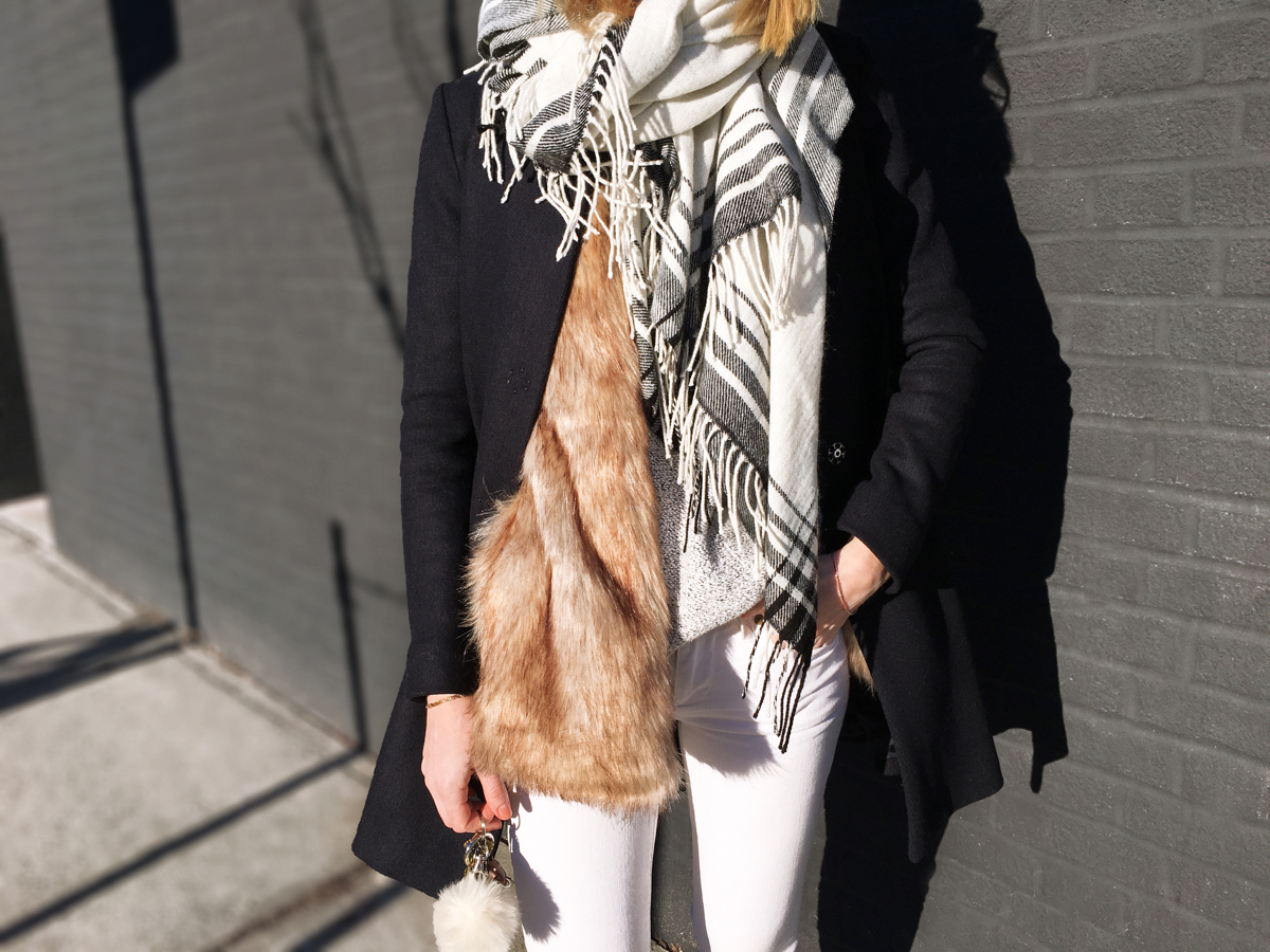 Detail shot of fur vest with navy coat