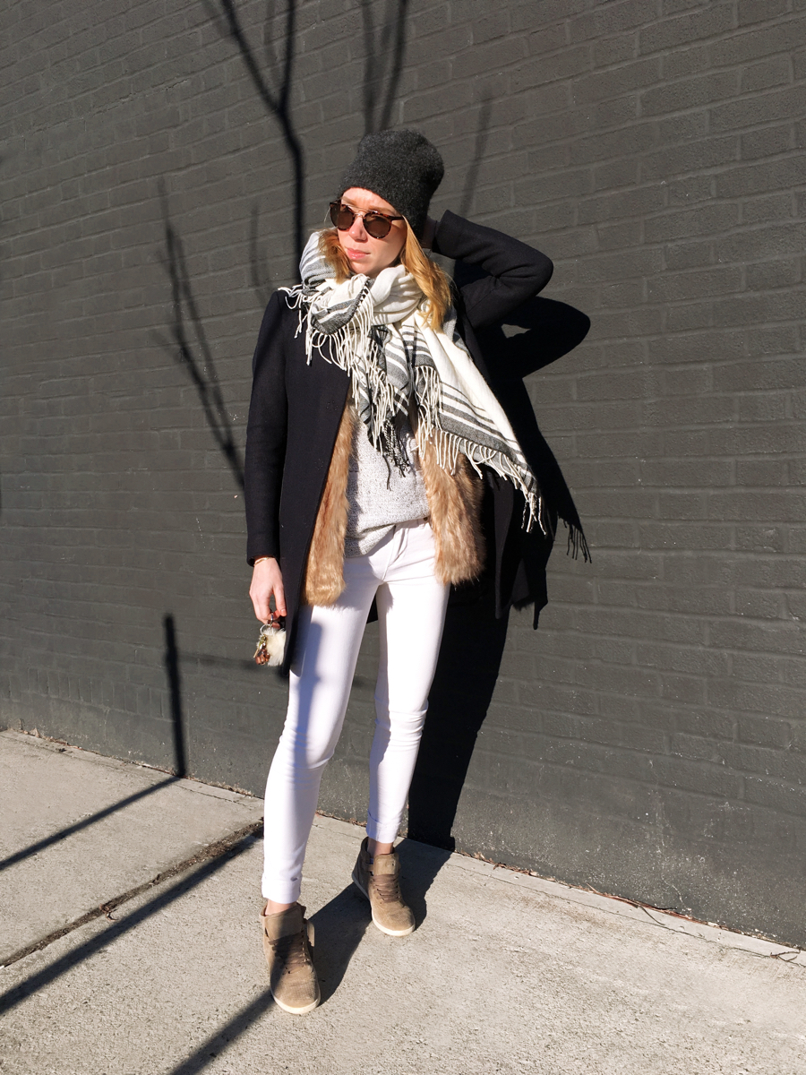 Woman posing in outfit against brick wall