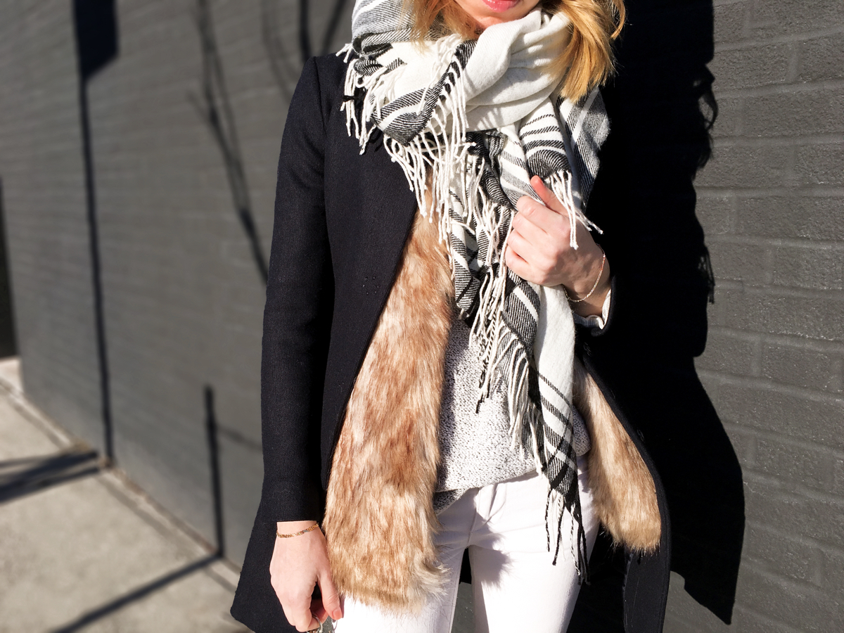 Detail shot of fur vest with navy coat and white scarf