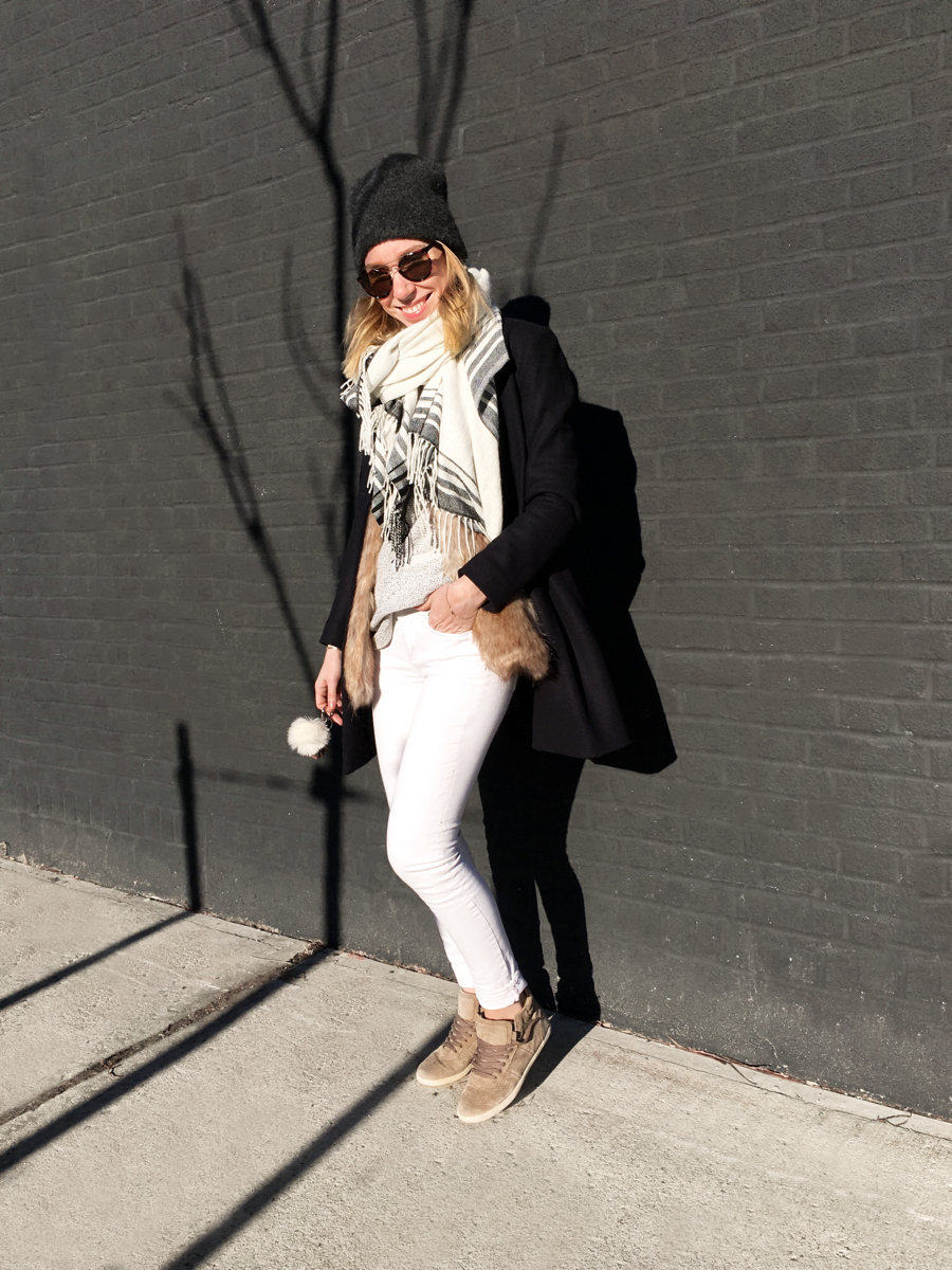 Woman posing in outfit against brick wall