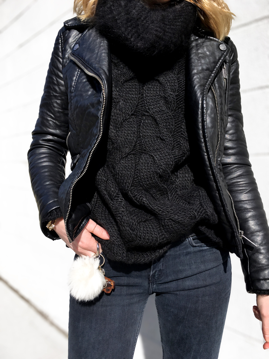 Front detail shot of black sweater with black leather jacket