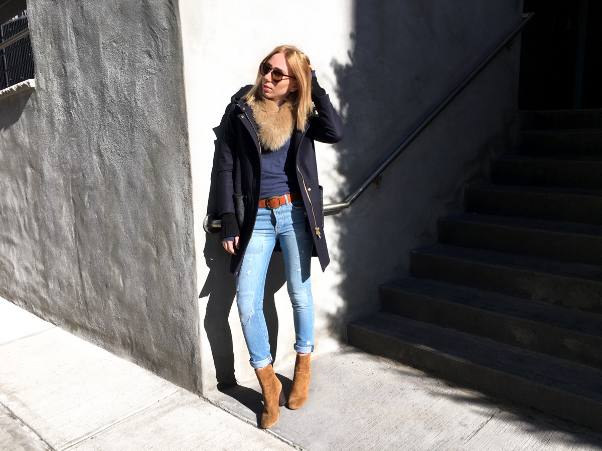 Woman posing in navy outfit against white wall