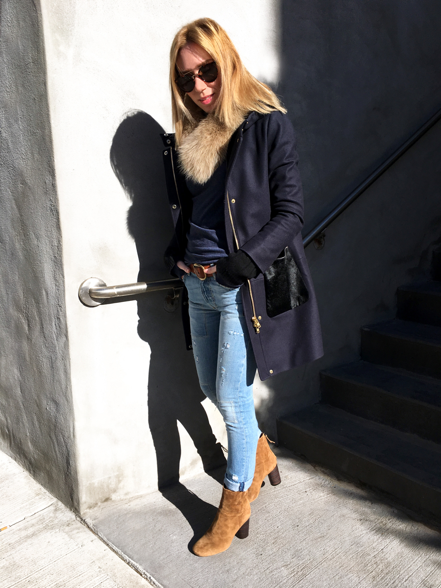 Woman posing in jeans and navy coat