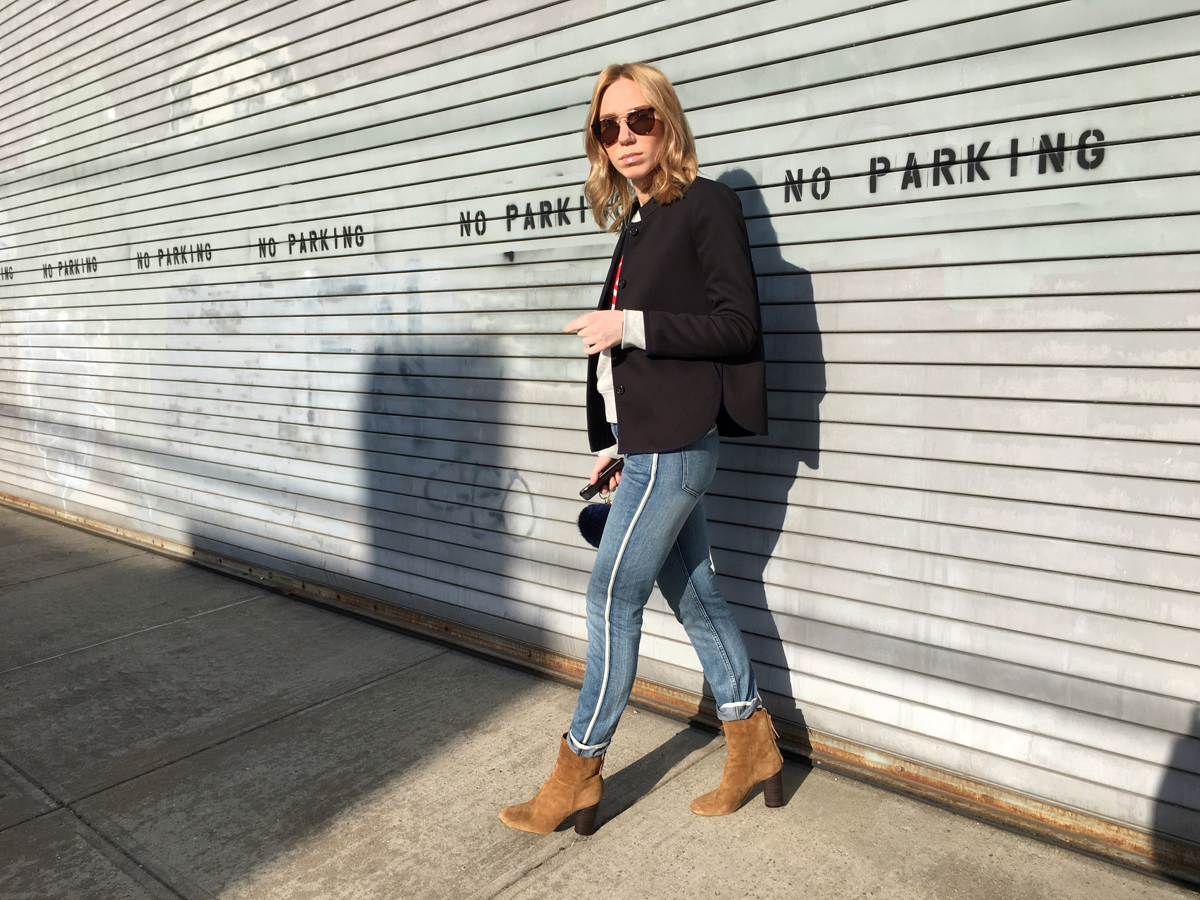 Woman posing wearing navy coat with jeans