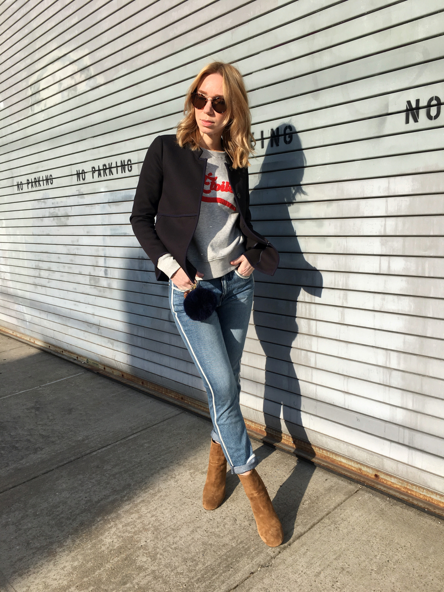 Woman posing in outfit against grey wall