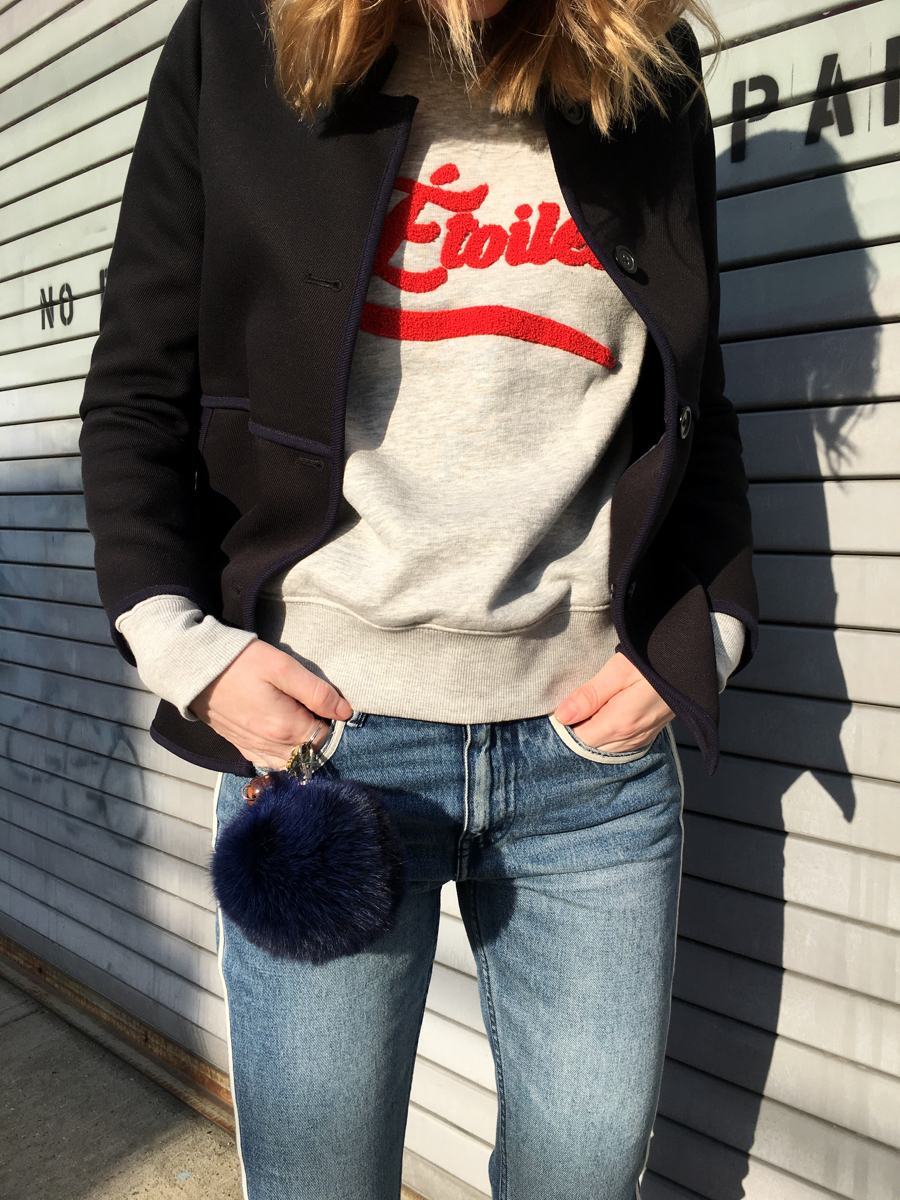 Detail shot of grey sweatshirt with red lettering and navy coat