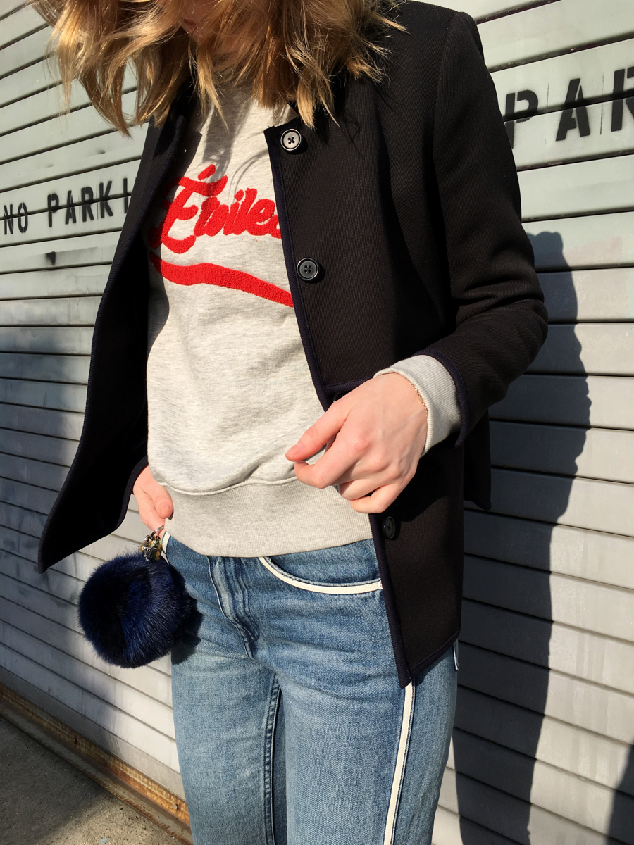 Detail shot of navy jacket with grey and red sweatshirt