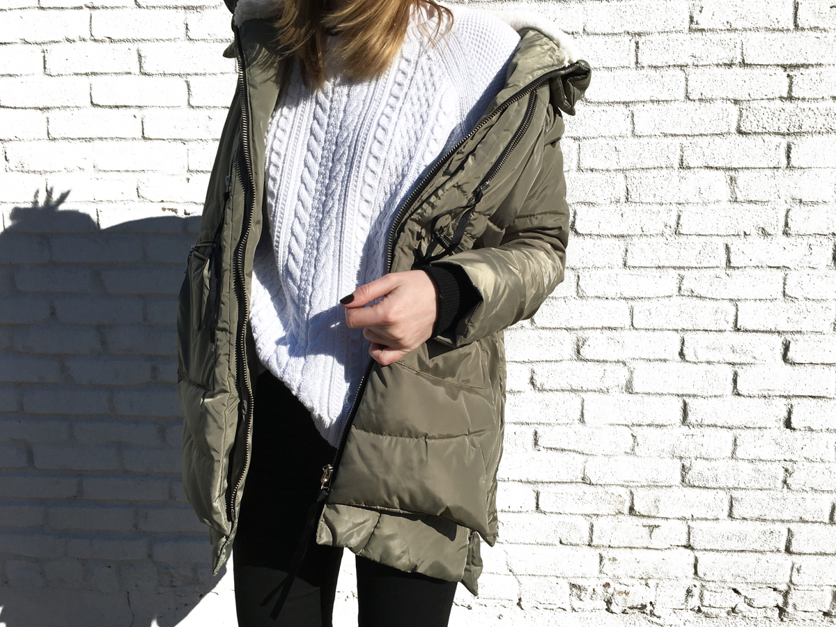 Detail shot of white sweater and olive jacket