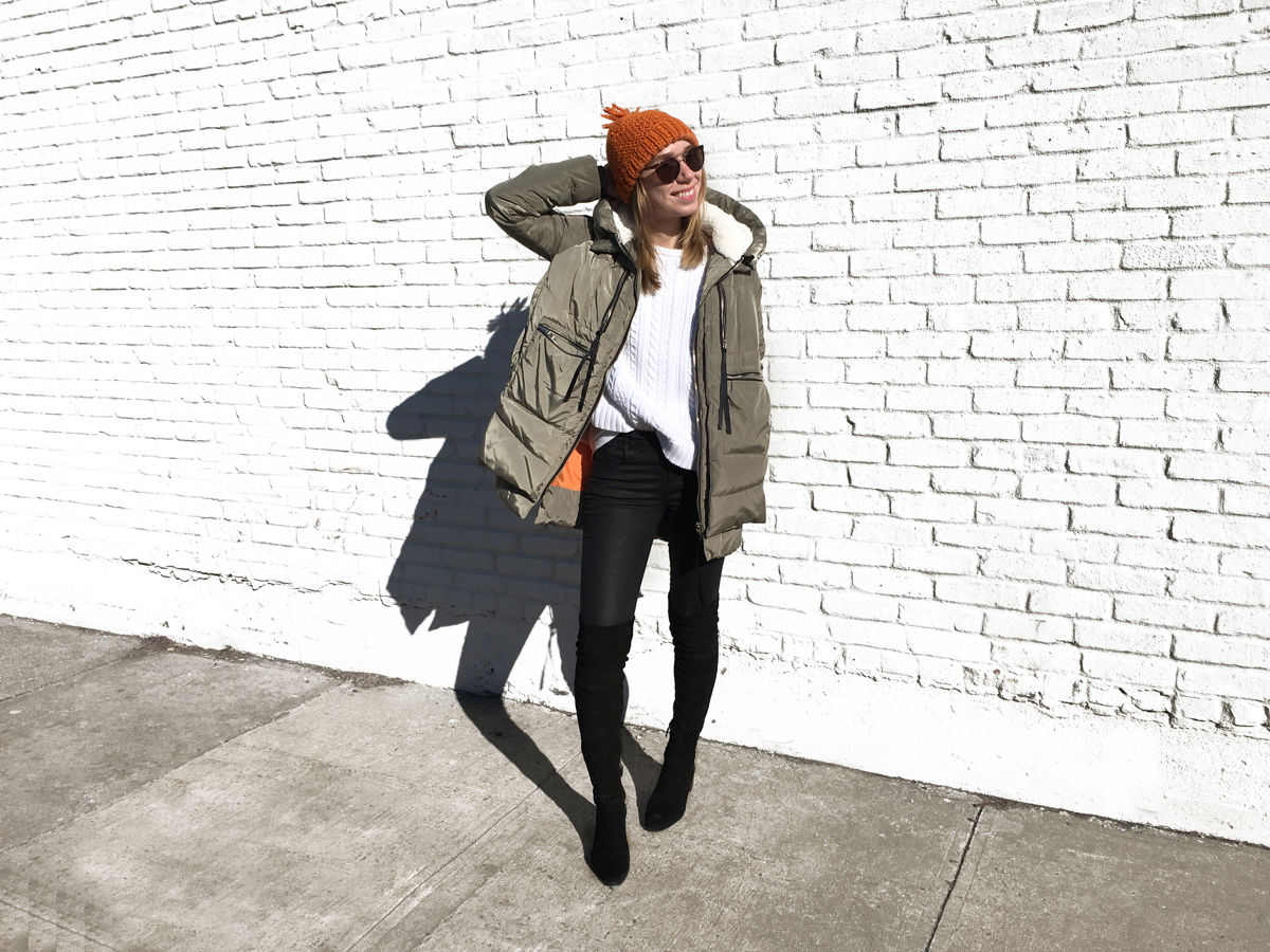 Woman posing in olive coat with orange beanie