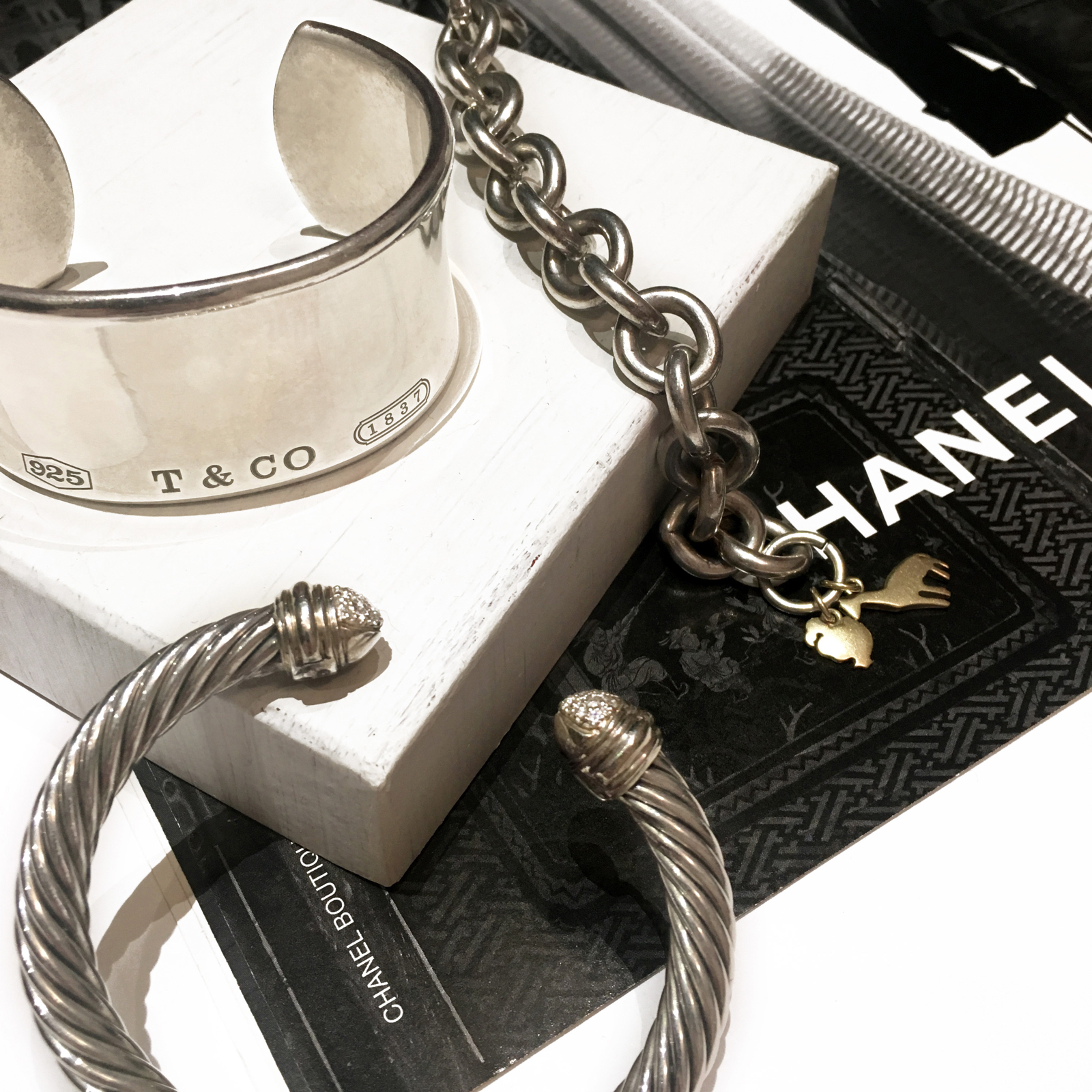 Silver bracelets laid out on top of a magazine