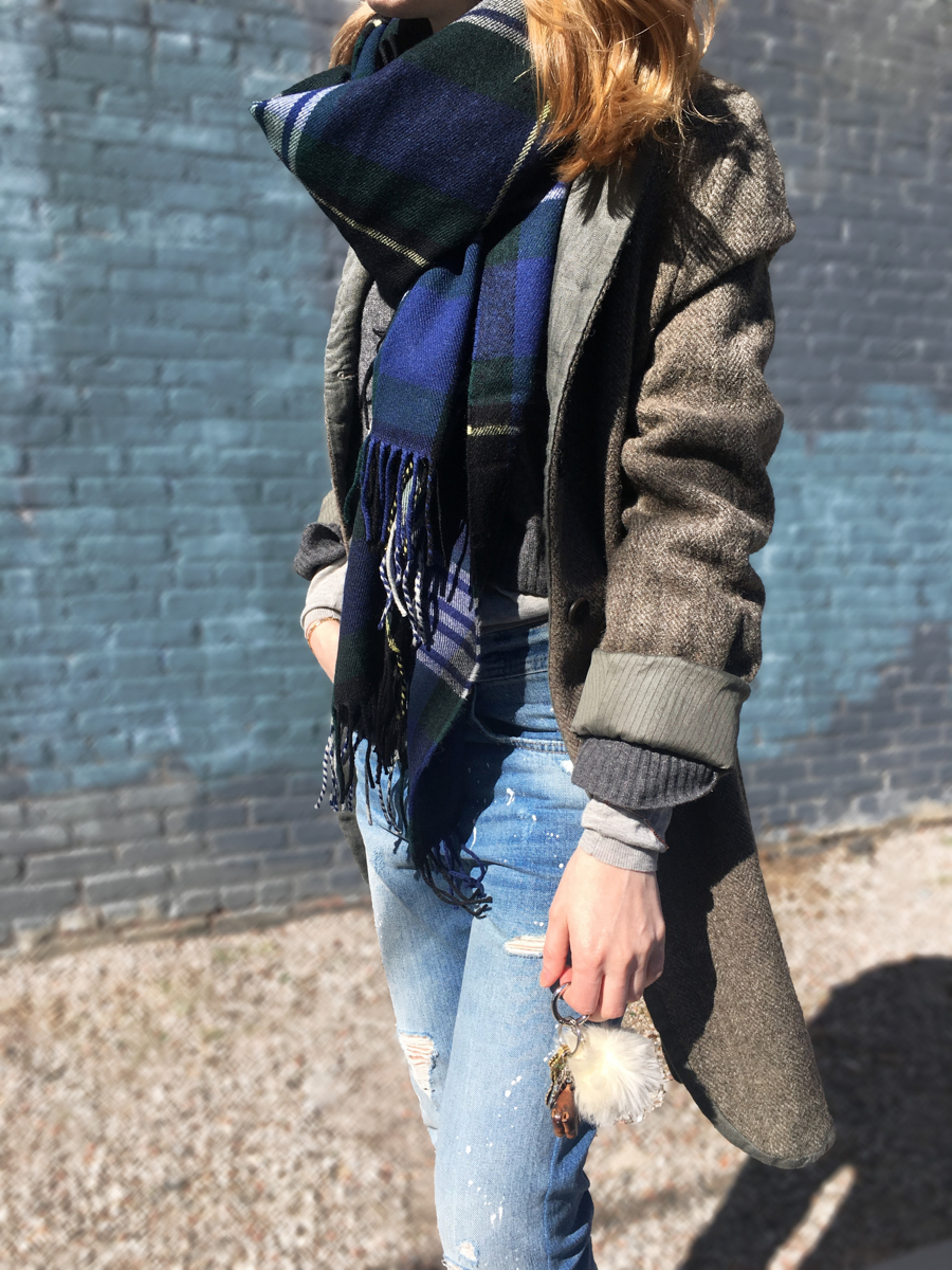 Side detail shot of woman wearing coat and plaid scarf
