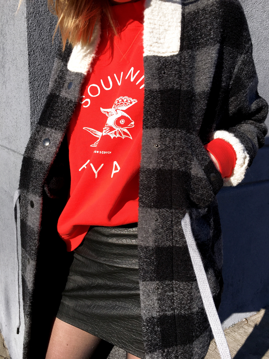 Detail shot of Isabel Marant jacket and red sweater