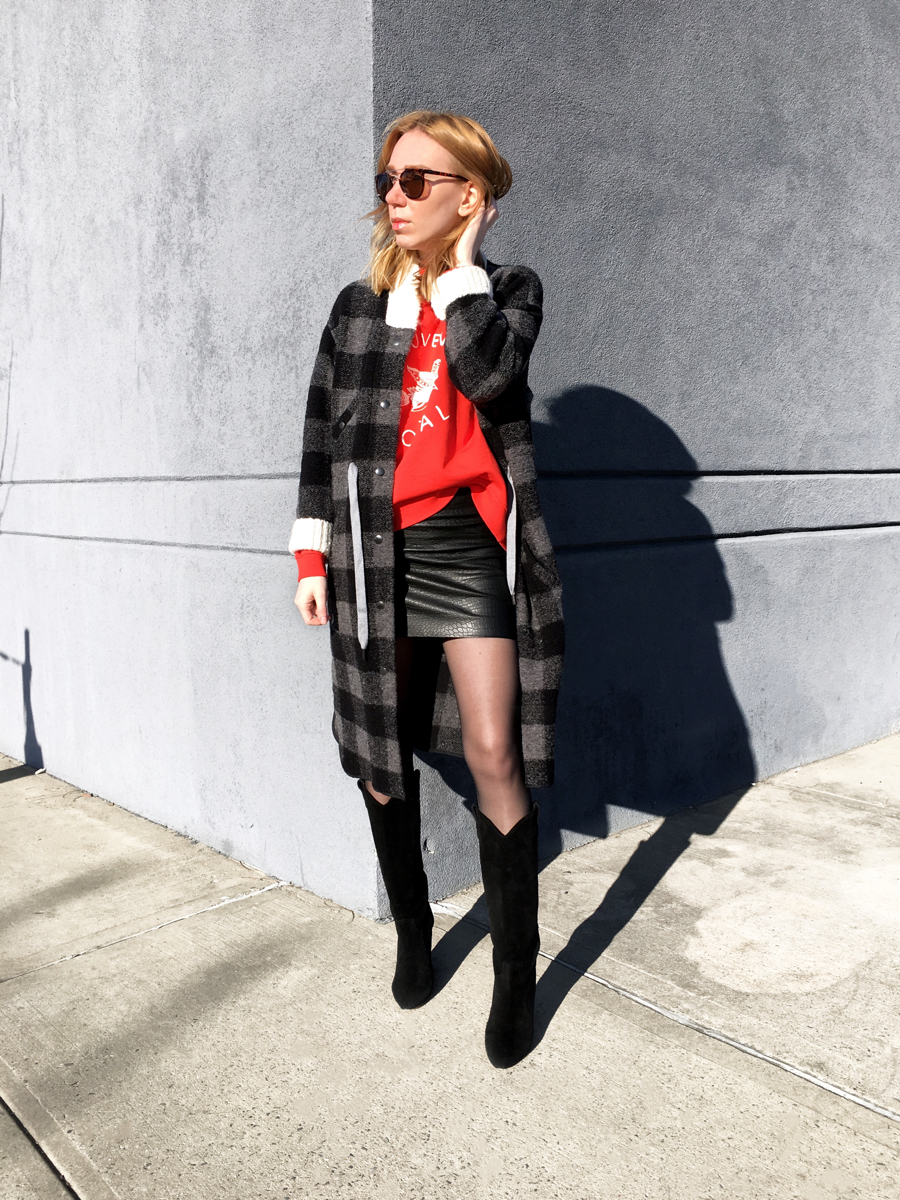 Woman posing in streetstyle photo against grey wall