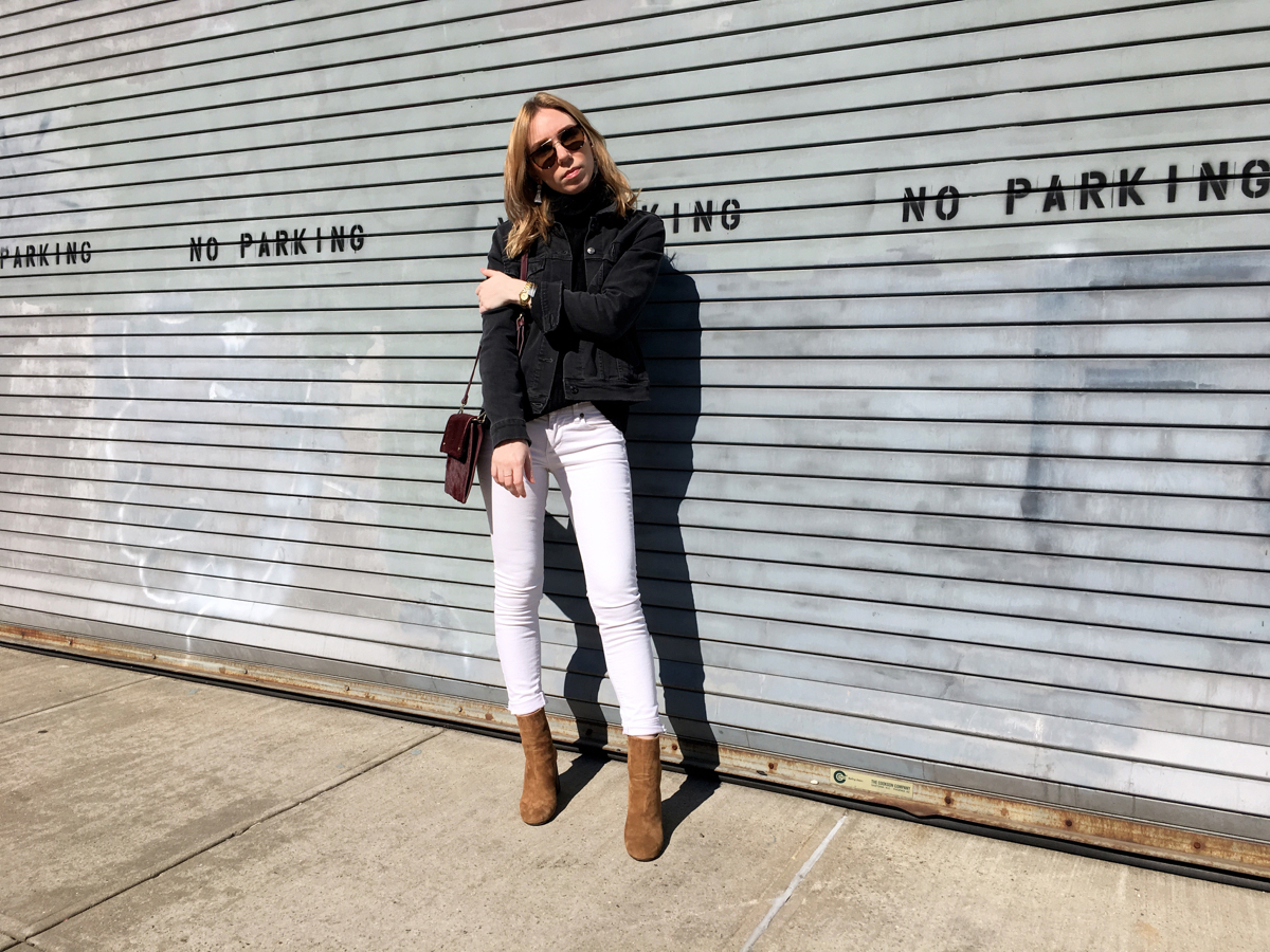 Woman posing in white jeans and grey denim jacket