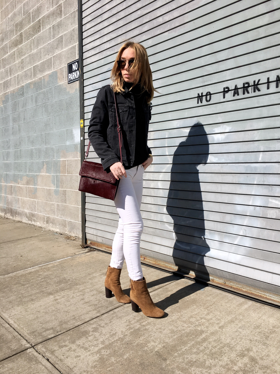Woman walking in white denim jeans and grey jacket