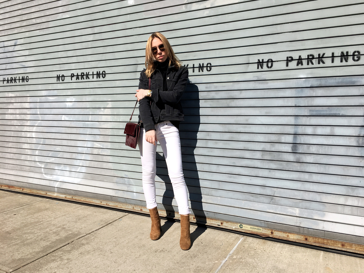 Woman posing in brown heels with white denim and grey jacket