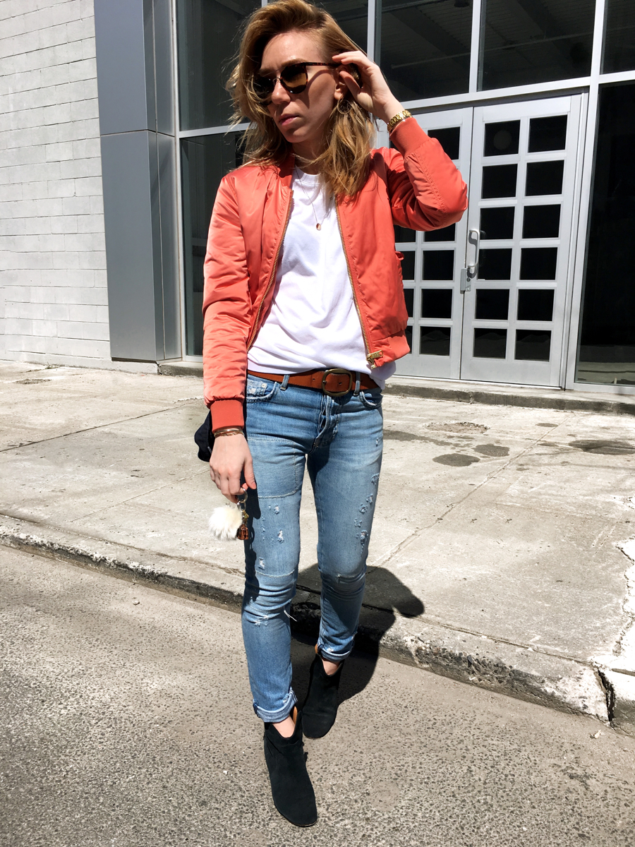 Woman wearing pink bomber with jeans and tee