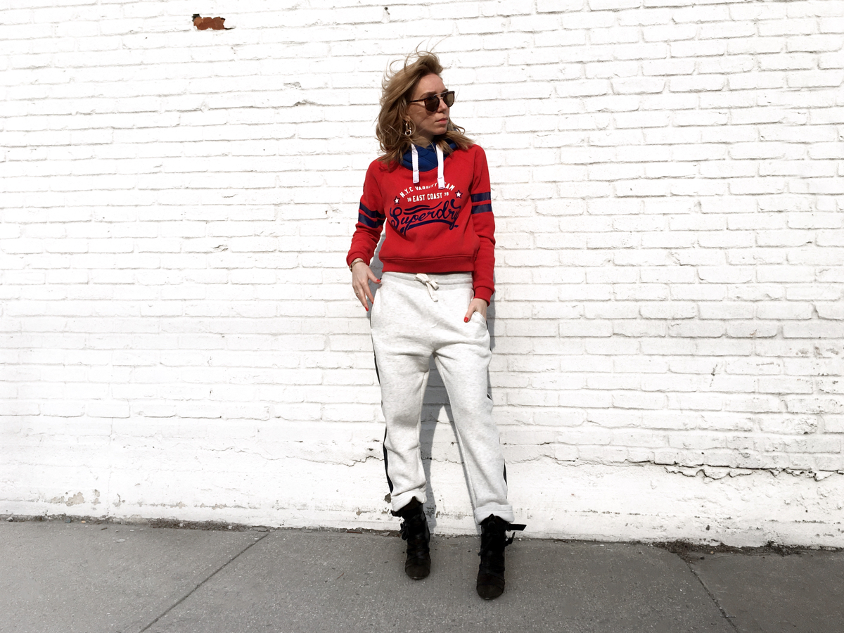 Woman posing wearing red Superdry sweatshirt