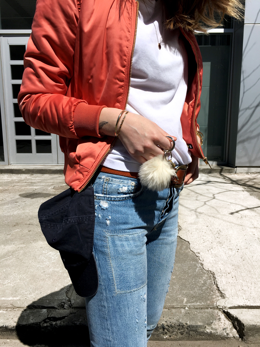 Side detail shot of white tee with pink bomber and jeans