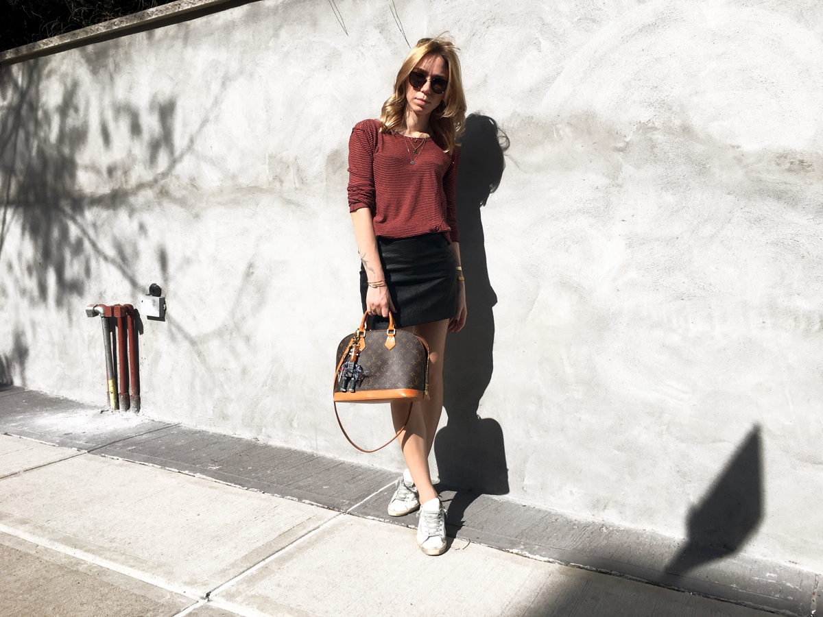 Woman posing in red sweater with black mini skirt outfit