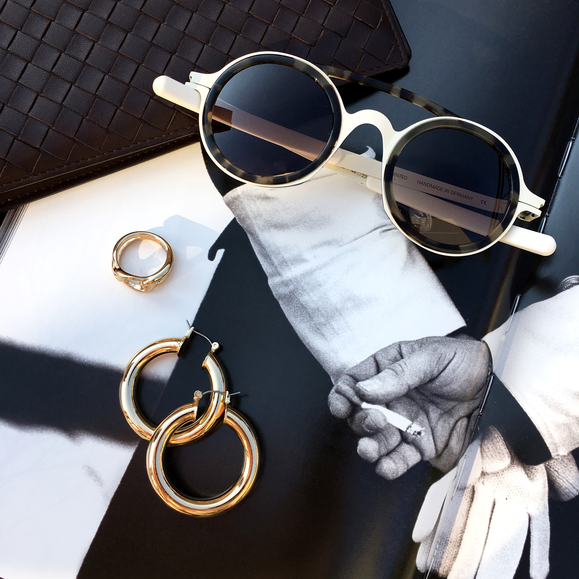 Sunglasses placed on magazine with jewelry