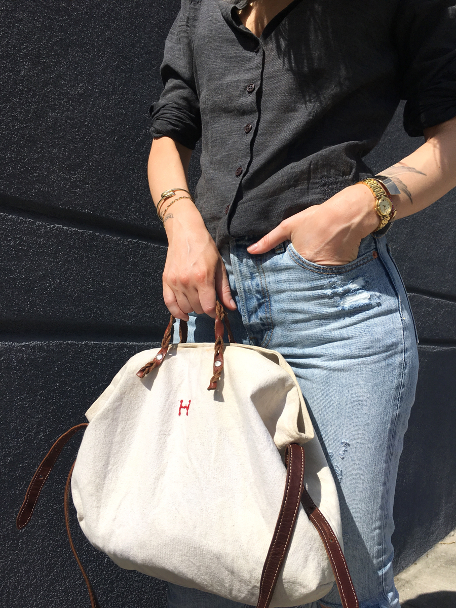 Detail shot of grey button down shirt and beige tote