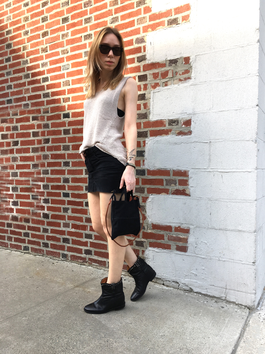 Woman posing in street style photo wearing beige knit top and black skirt